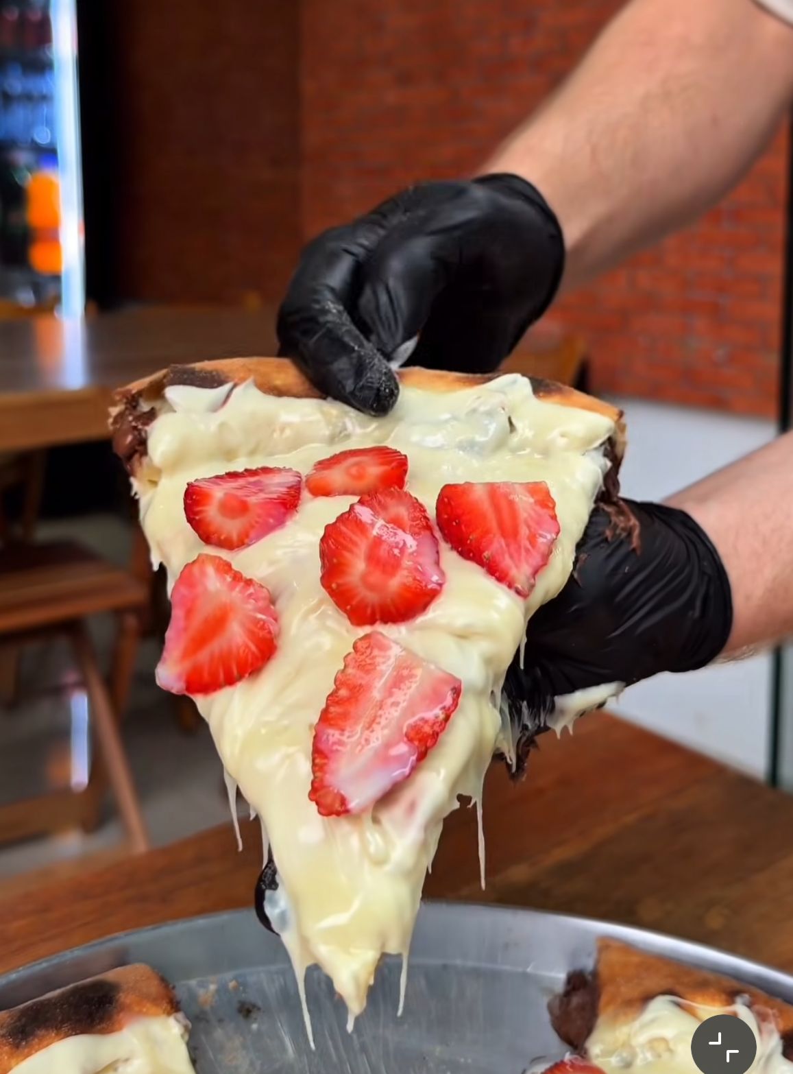 Fatia de pizza da Grã-Fina puxando muito queijo, com morangos